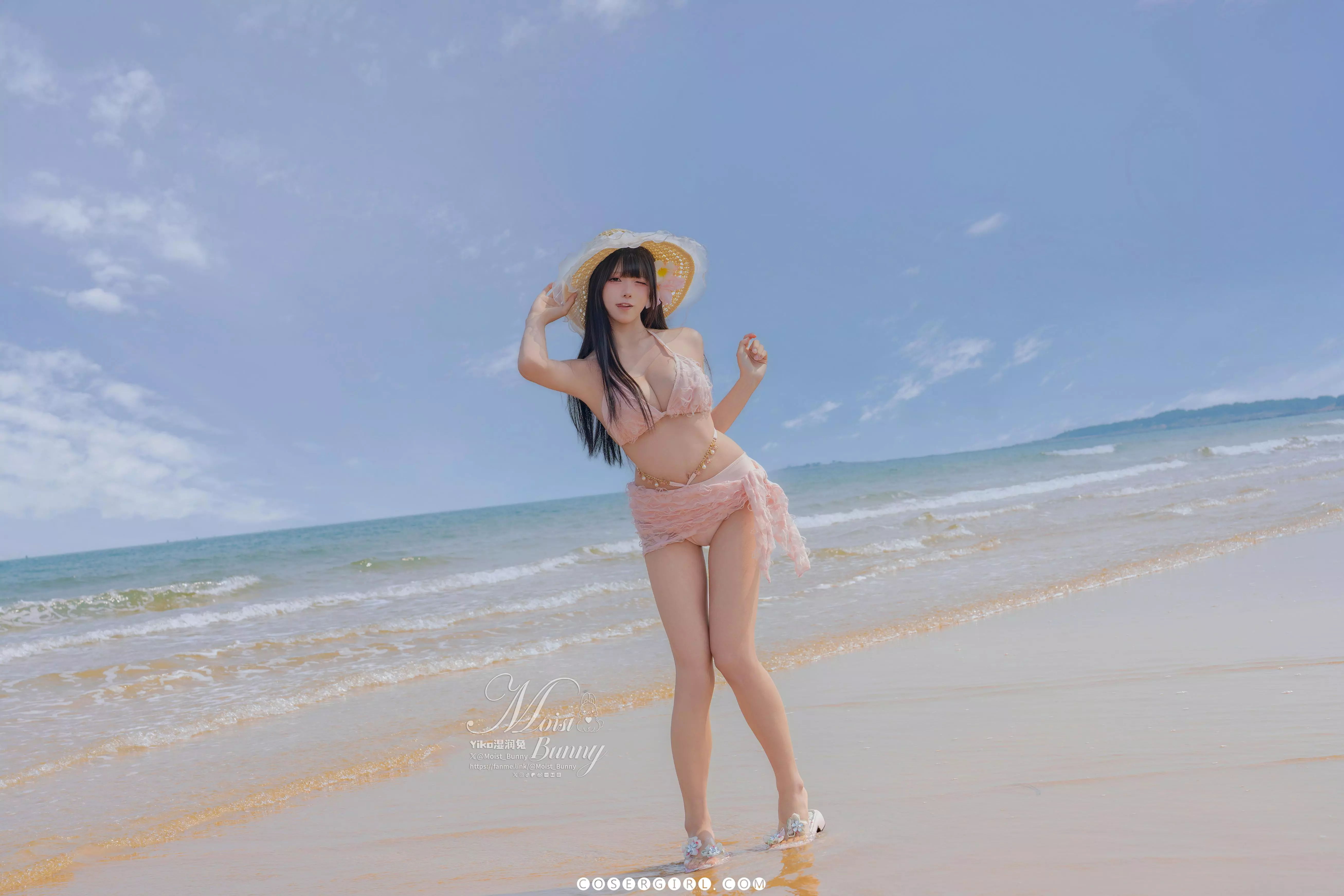 黏黏团子兔在沙滩上全身站立,一手轻扶草帽,展示出修长的双腿和曼妙的身姿。