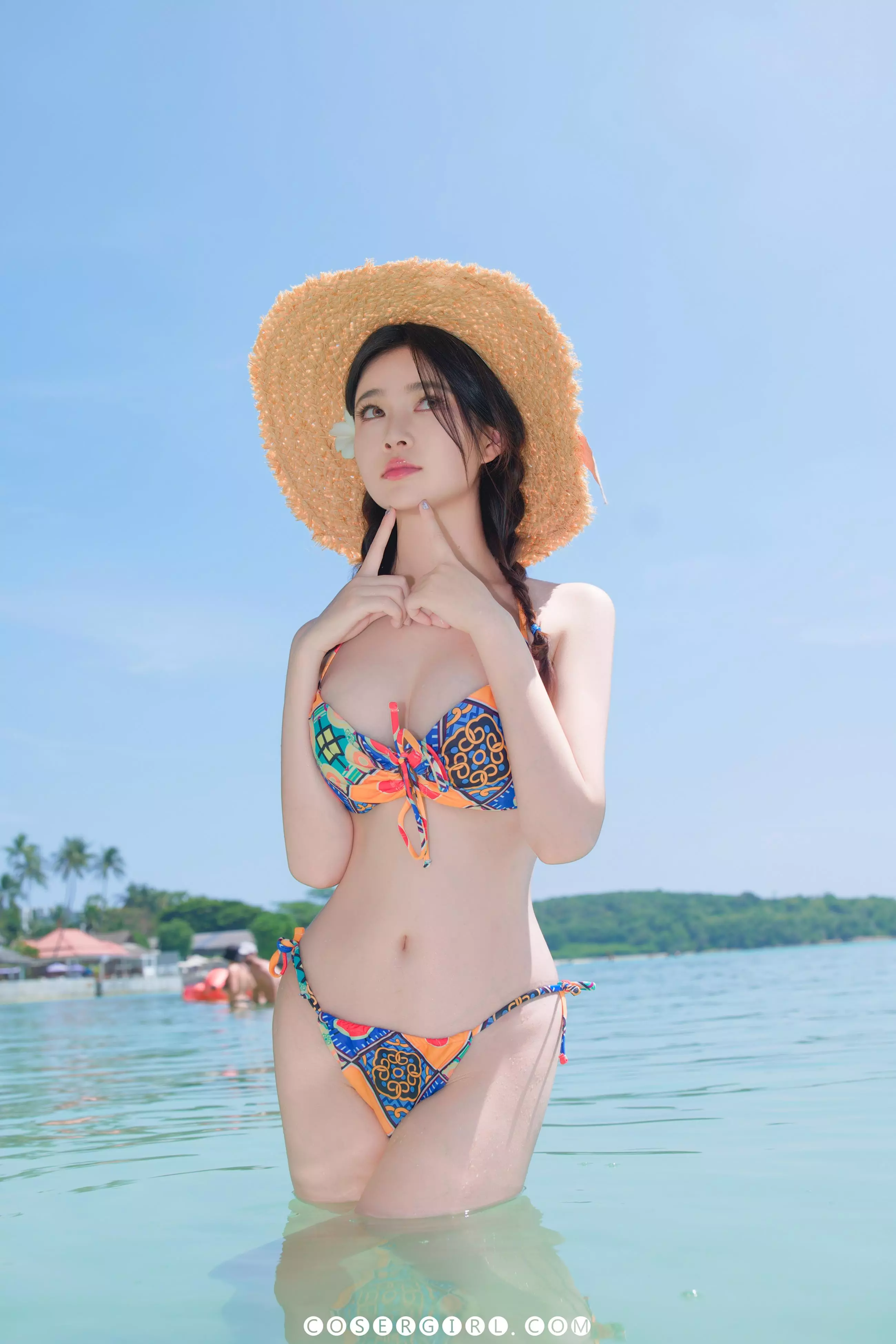 Coser年年站在海水中,一手托着下巴,眼神望向远方,表情俏皮可爱。