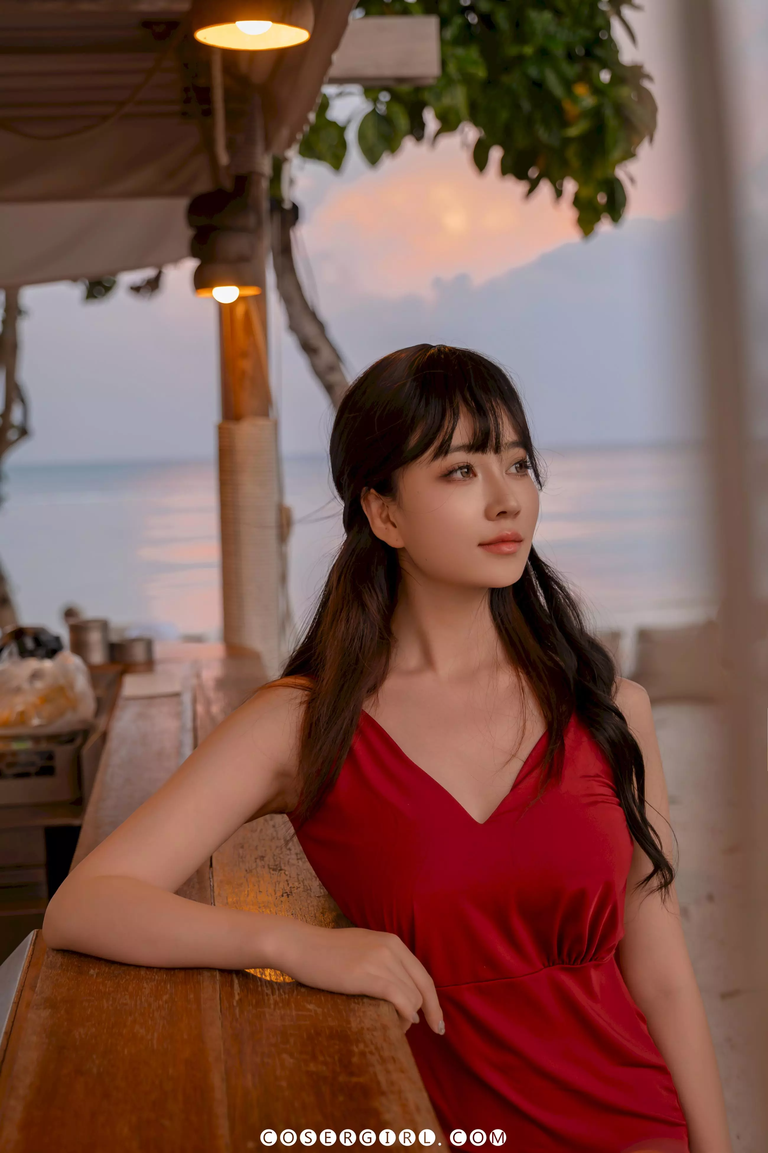 Coser年年靠在吧台上,侧头望向远方的海面,眼神放空