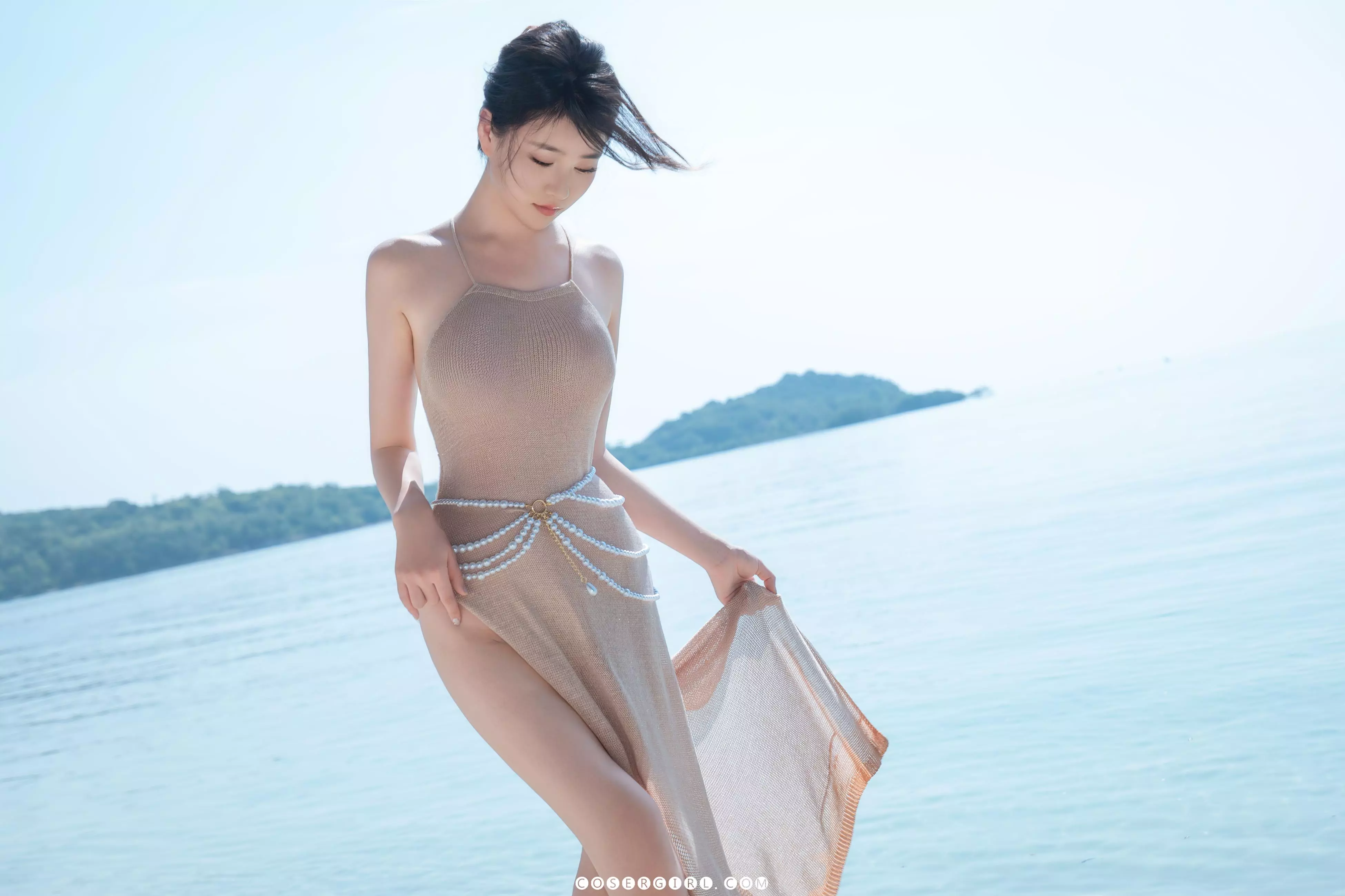 年年低头轻抚裙摆,海风吹动发丝