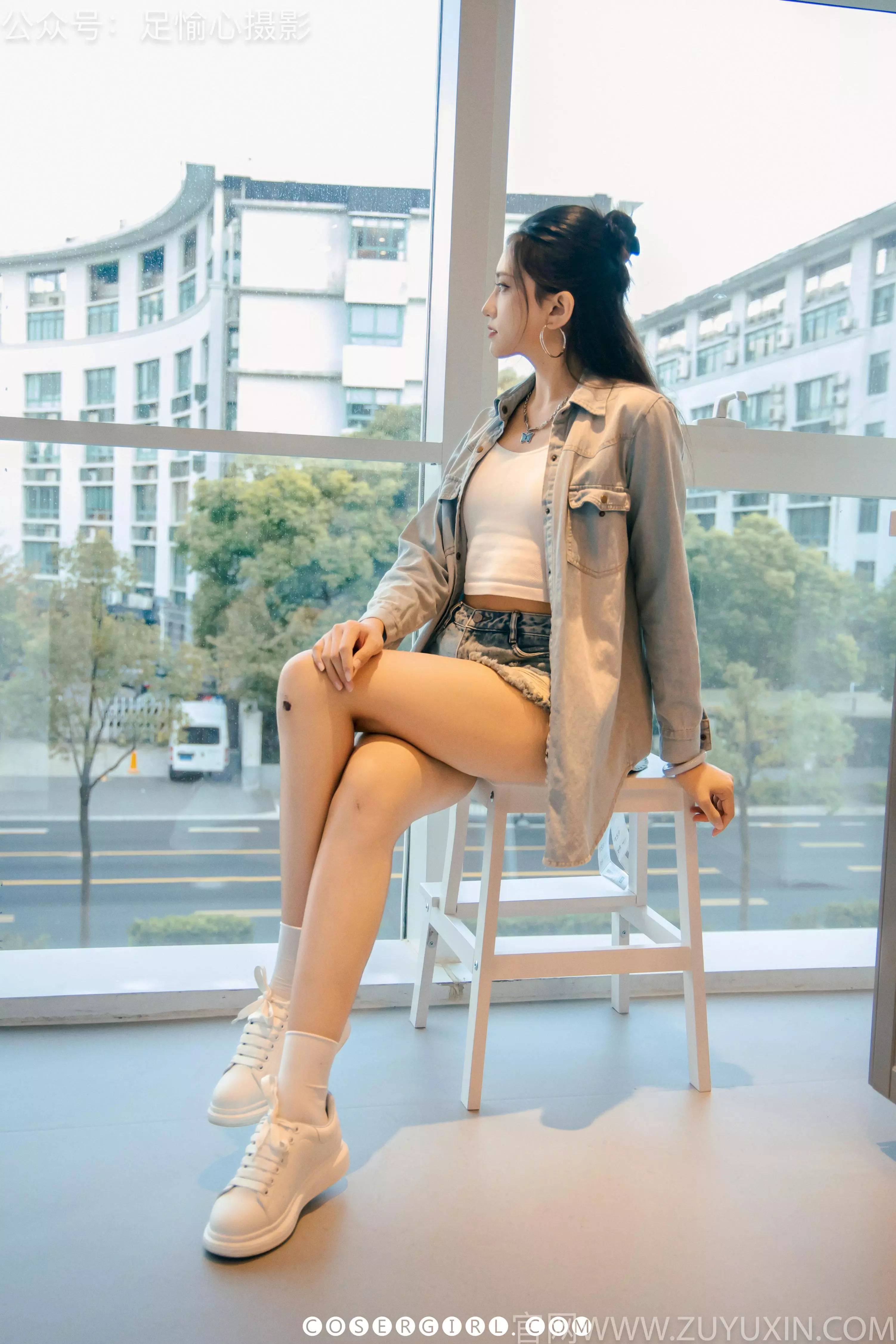 足愉心坐在购物车里,双腿伸直搭在车筐边缘,镜头聚焦在她穿着白色棉袜的双脚上。