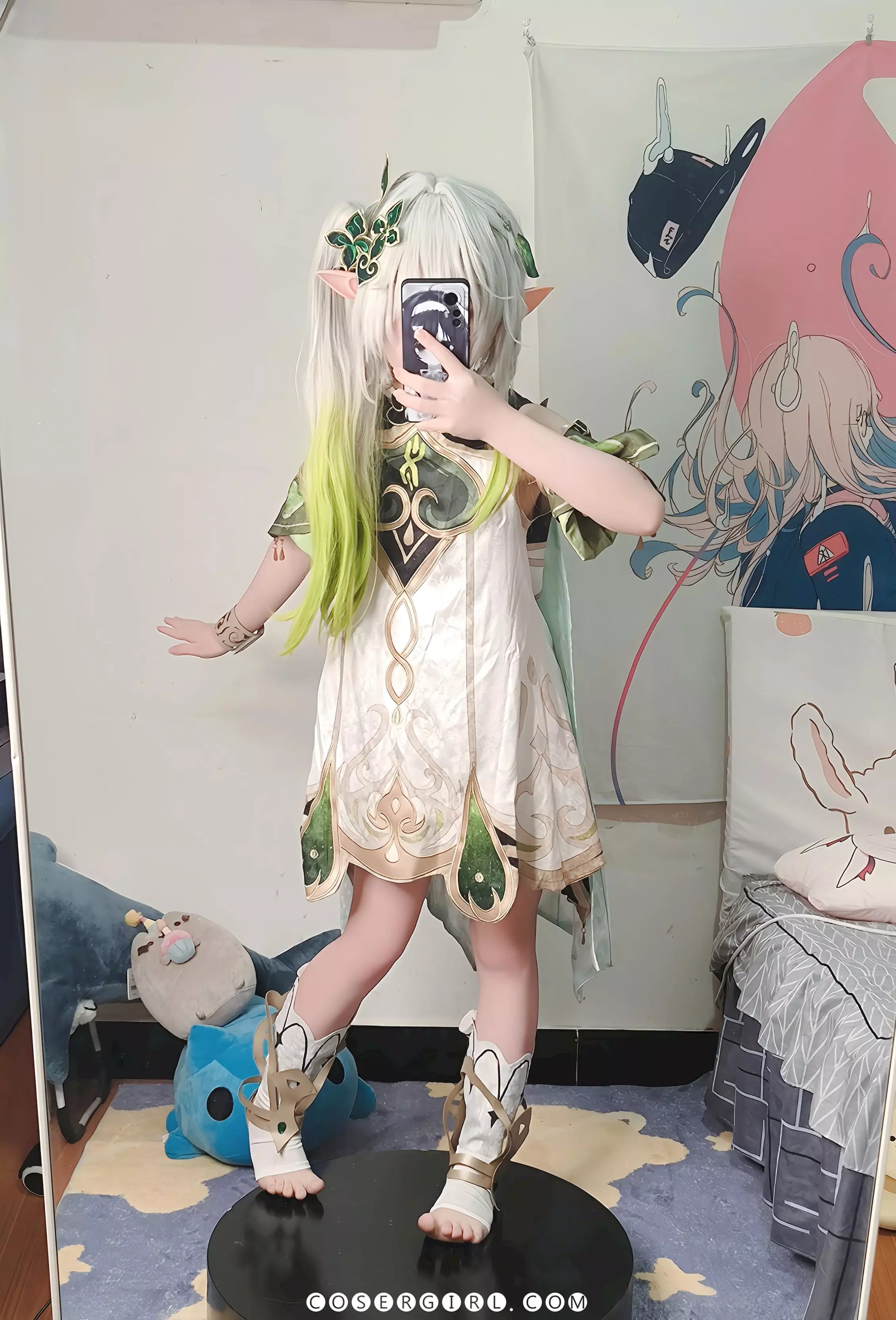 ran3扮演的纳西妲站在一个黑色圆盘上,在镜子前自拍,显得身形更加修长。