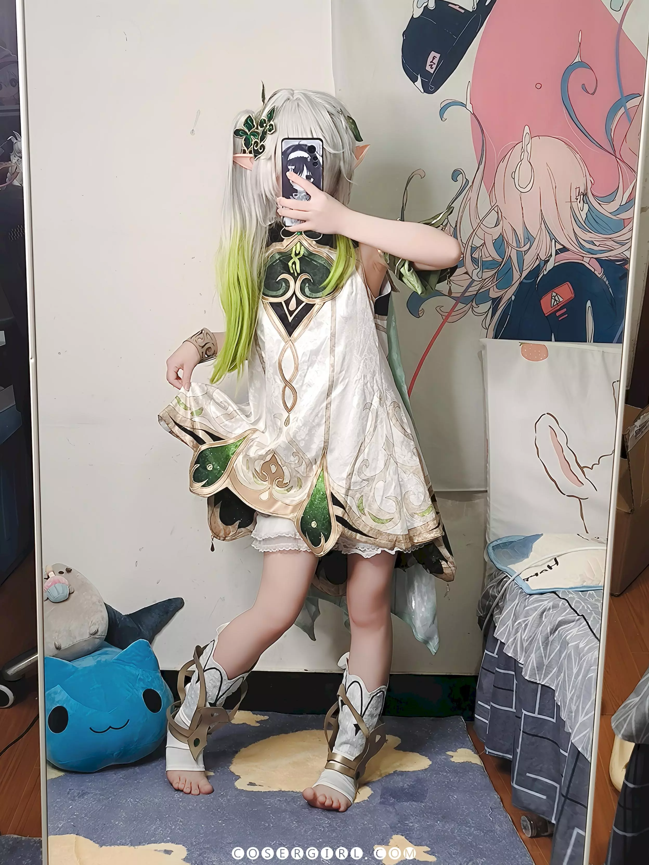 ran3扮演的纳西妲站在全身镜前,提起裙摆,展示她的小白靴和光洁的脚丫,背景是她的卧室。