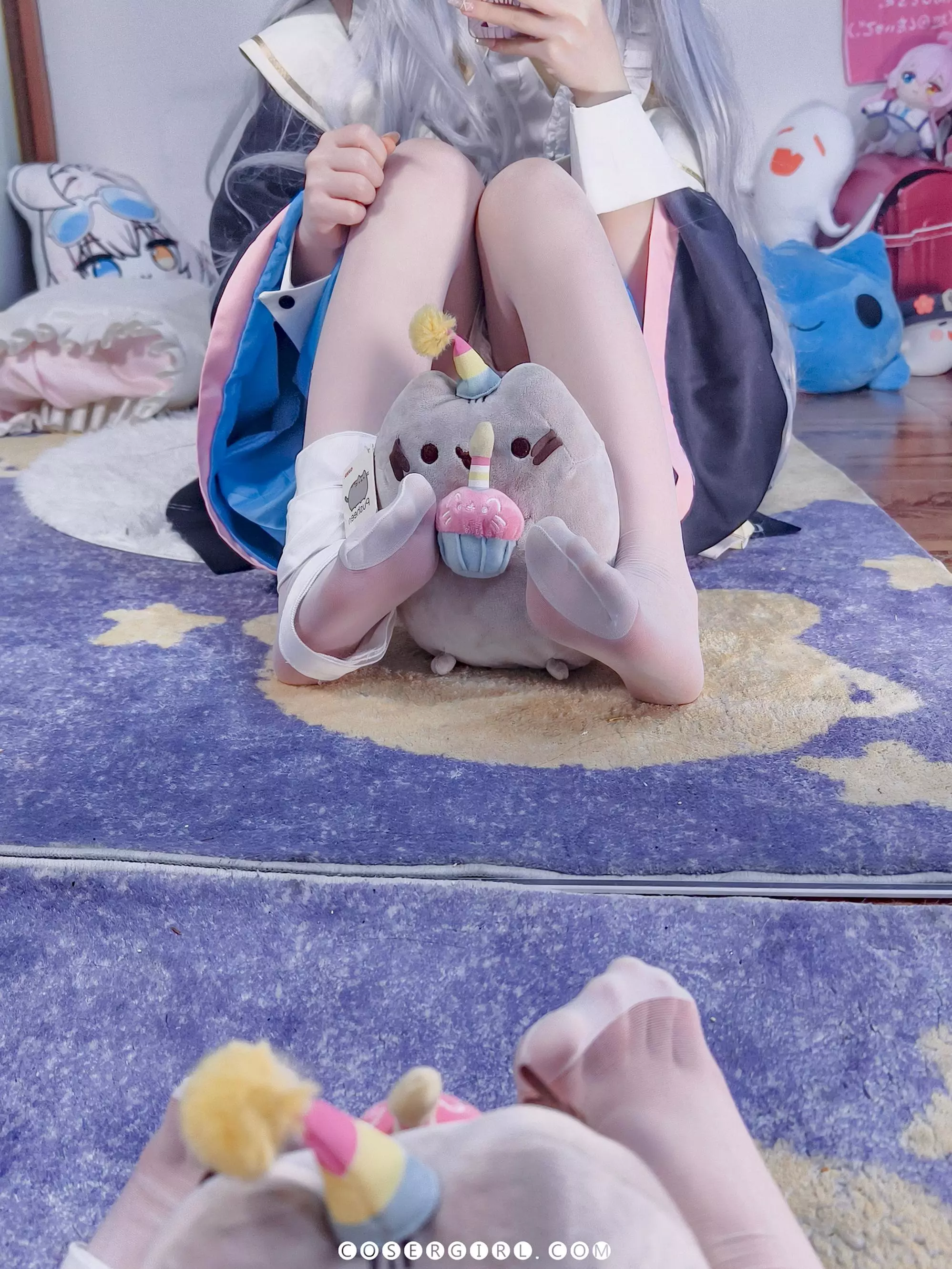 ran3扮演的神乐七奈坐在地毯上,双腿蜷缩,用手机挡住脸对着镜子自拍,姿态娇小可爱。