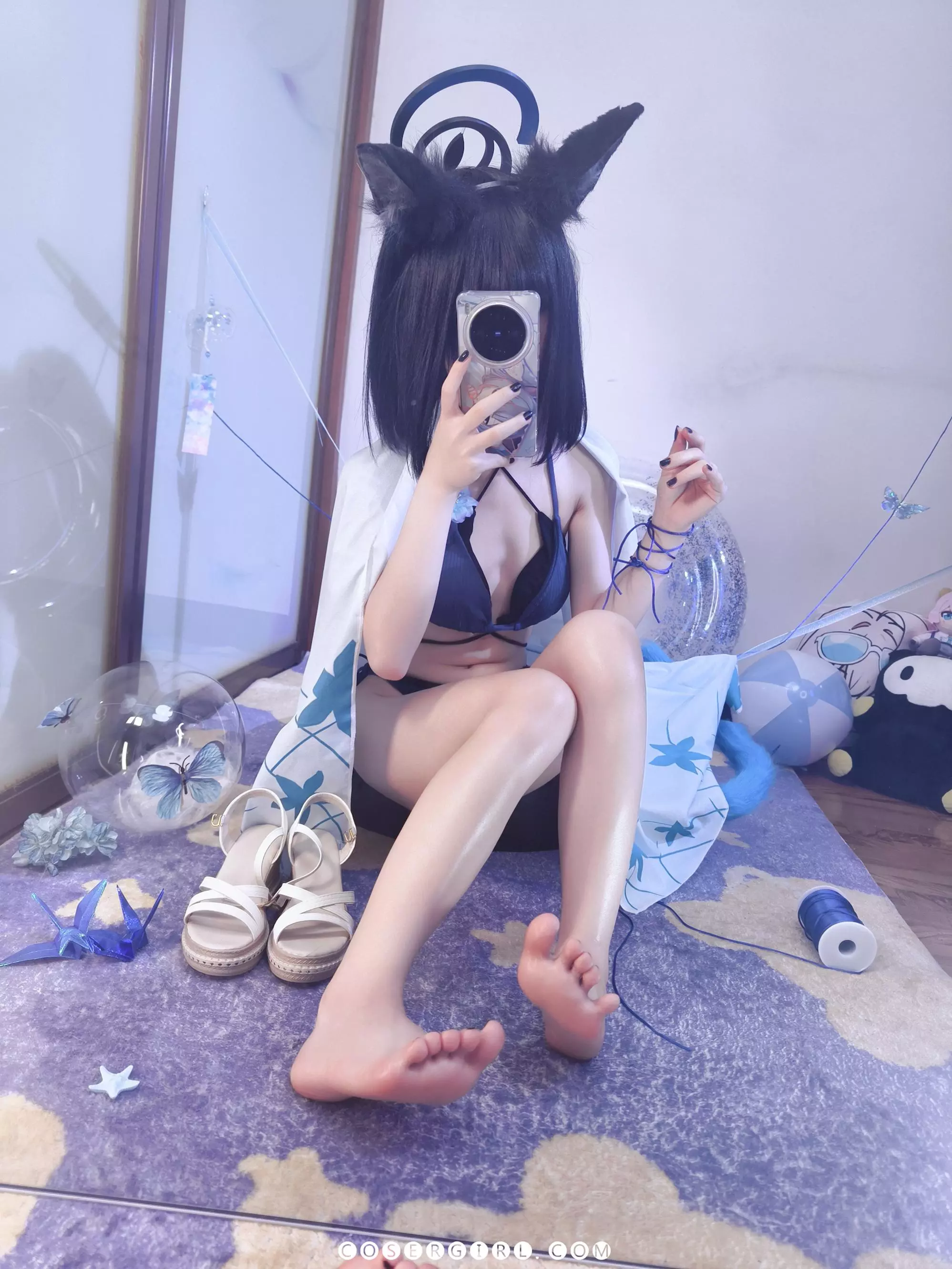 ran3扮演的水桔梗坐在地毯上,双脚并拢,脚心正对镜头,手上玩弄着蓝色丝线