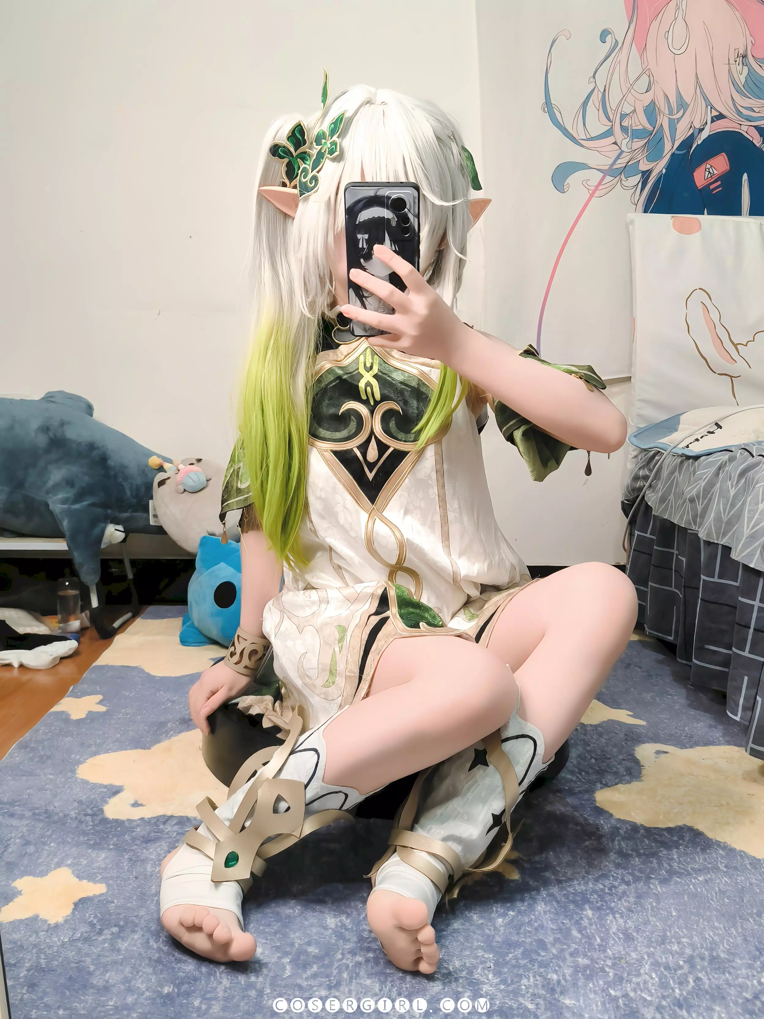 ran3扮演的纳西妲盘腿坐在地毯上,用手机对着镜子自拍,姿态放松可爱。