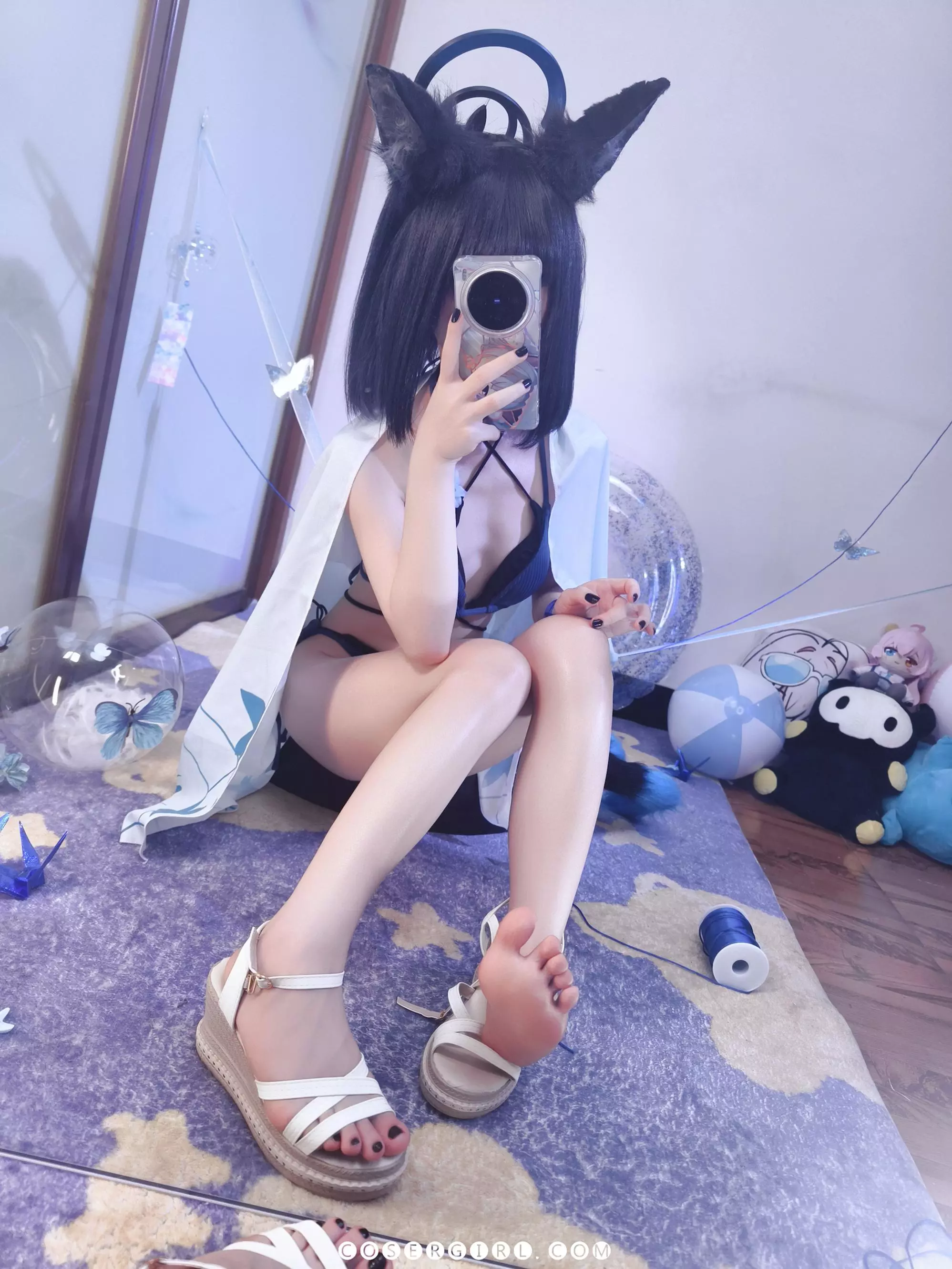 ran3扮演的水桔梗坐在地毯上,身边放着脱下的坡跟凉鞋和一卷蓝色线团,姿态放松