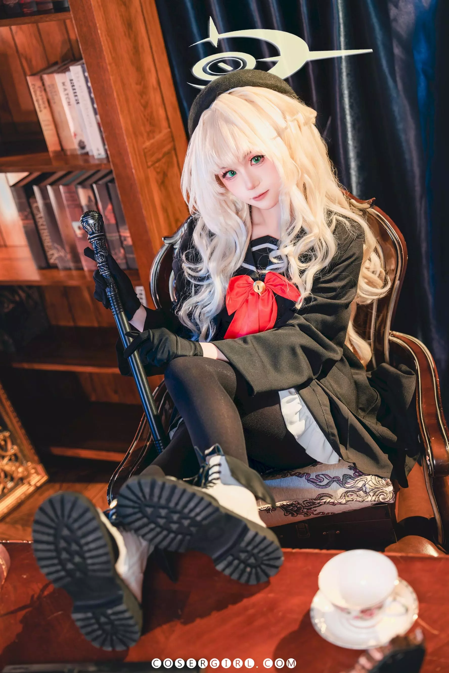 ran3扮演的笑面教授坐在椅子上,双腿并拢,穿着黑色制服和黑色丝袜,姿态端庄而可爱。