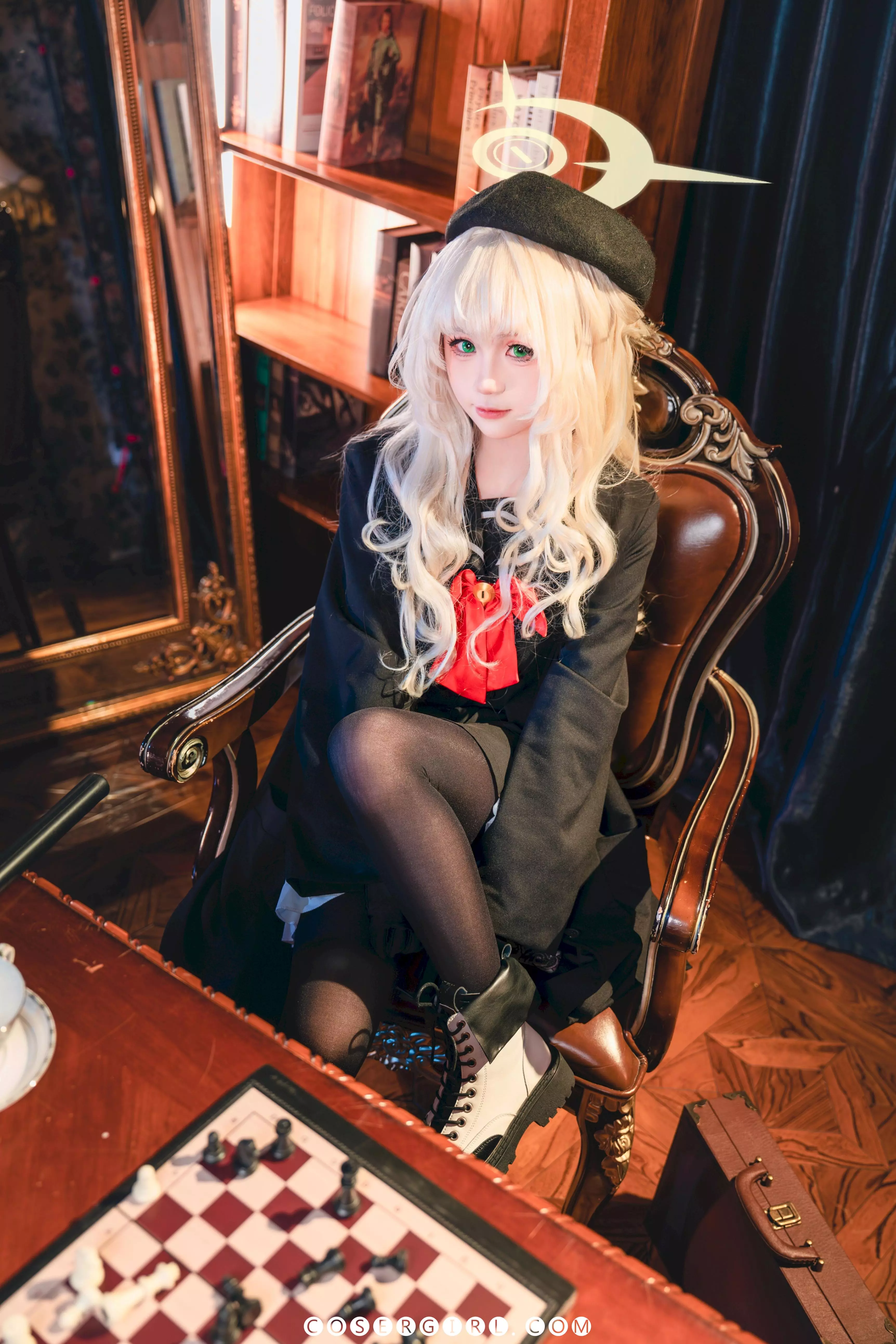 ran3扮演的笑面教授坐在椅子上身体后仰,脱下一半手套,一只穿着黑丝的脚掌踩在另一只脚上,姿态放松。