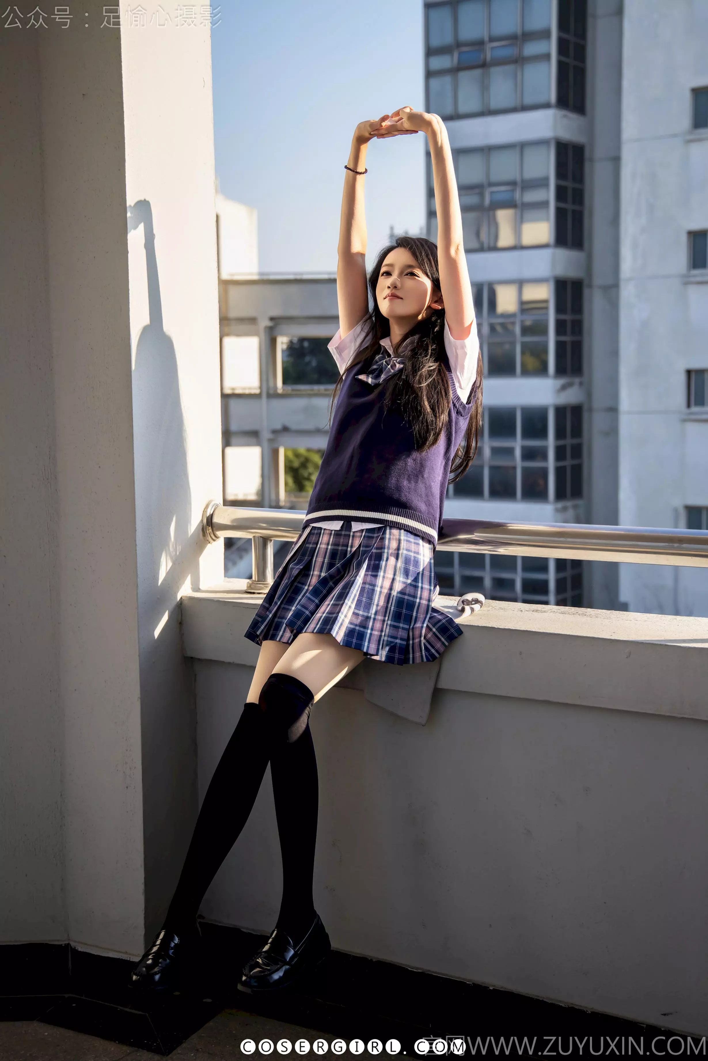 足愉心坐在阳台栏杆上，向后伸展双臂，阳光照在她身上。